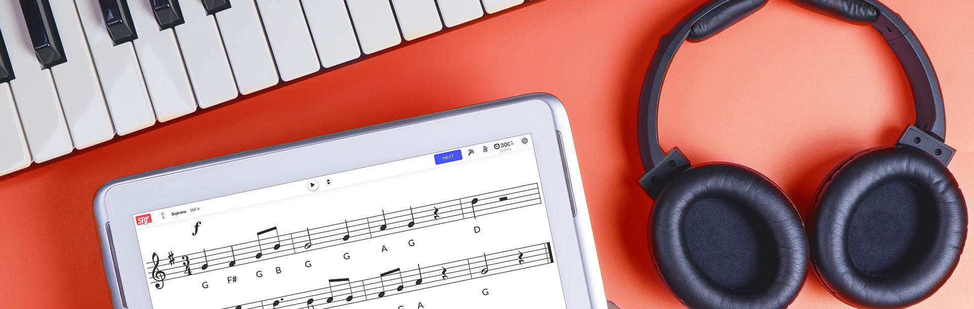 digital piano, headphones, ipad with Sight Reading Factory displayed on it