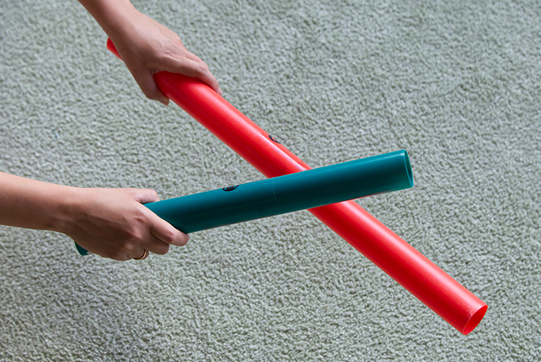hands striking two boomwhackers together