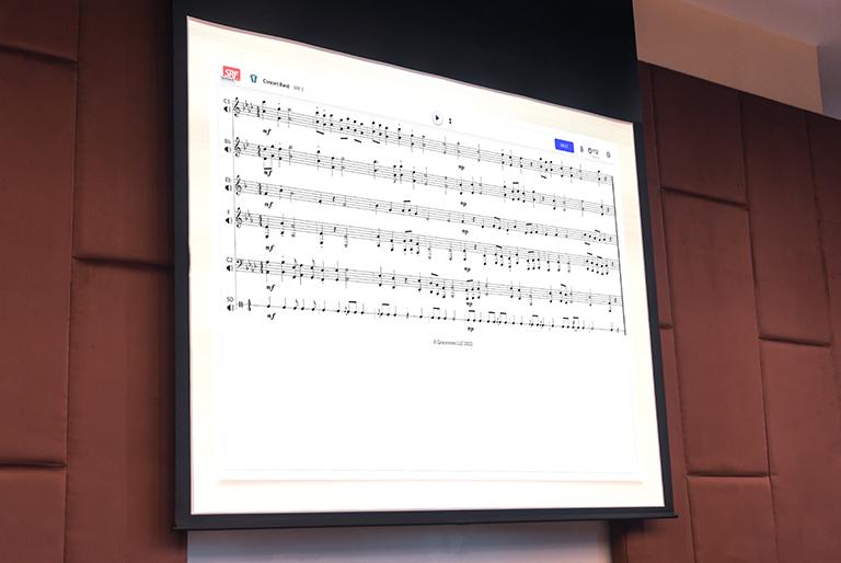 Sight Reading Factory exercise for concert band displayed on a projector screen.