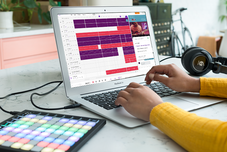 Young woman using laptop computer with Launchkey Mini plugged in and Soundtrap for Education software open on the laptop screen