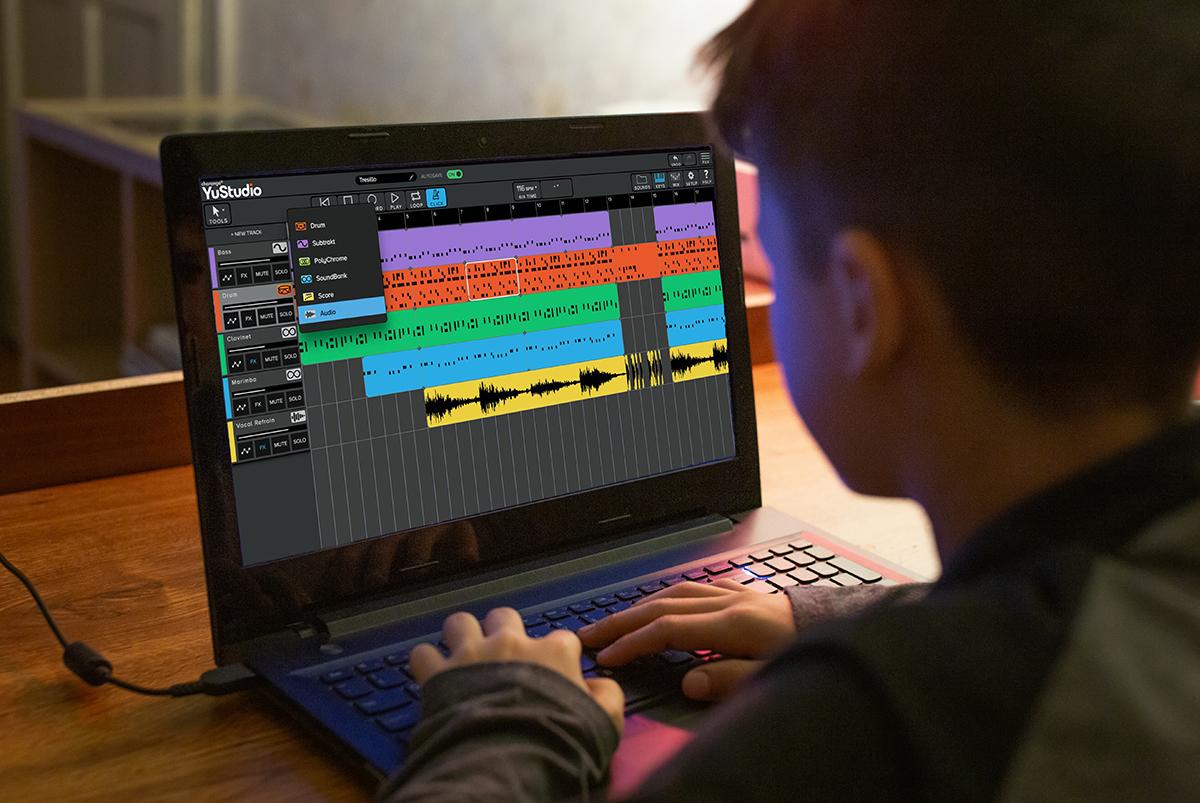 Boy looking at laptop with YuStudio software open on the screen