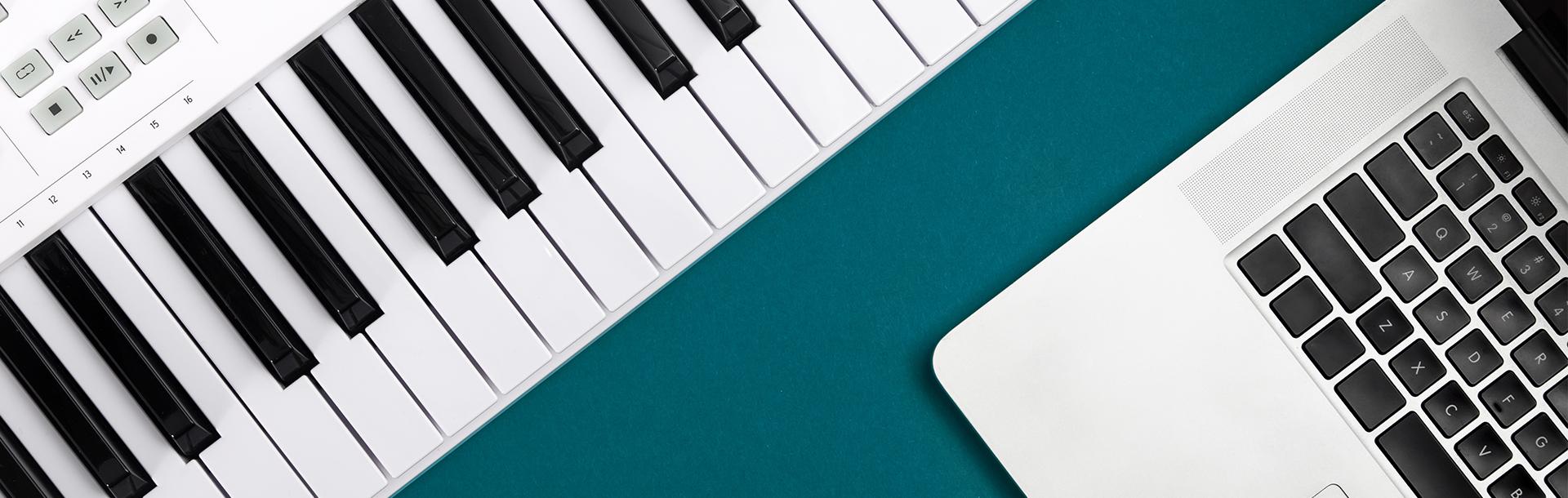 digital piano and laptop computer flat-lay on teal background